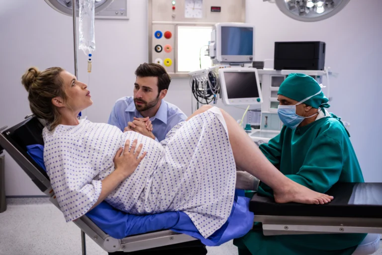 doctor examining pregnant woman delivery while man holding her hand