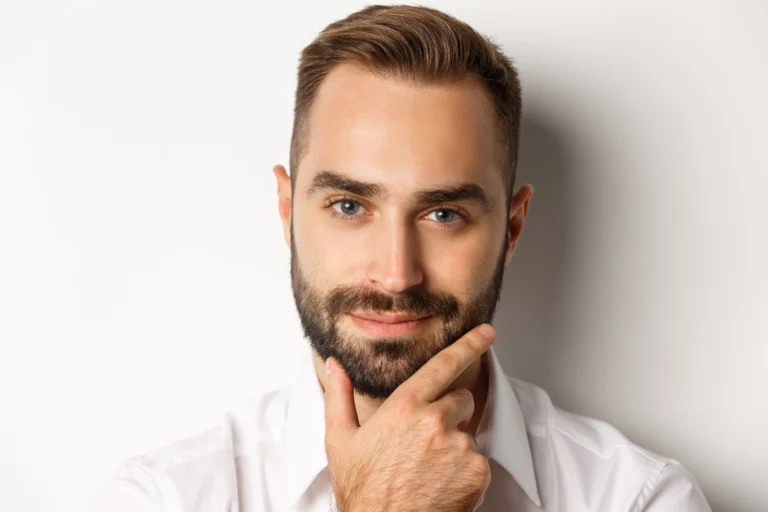 emotions people concept headshot handsome thoughtful man smiling satisfied touching beard thinking standing