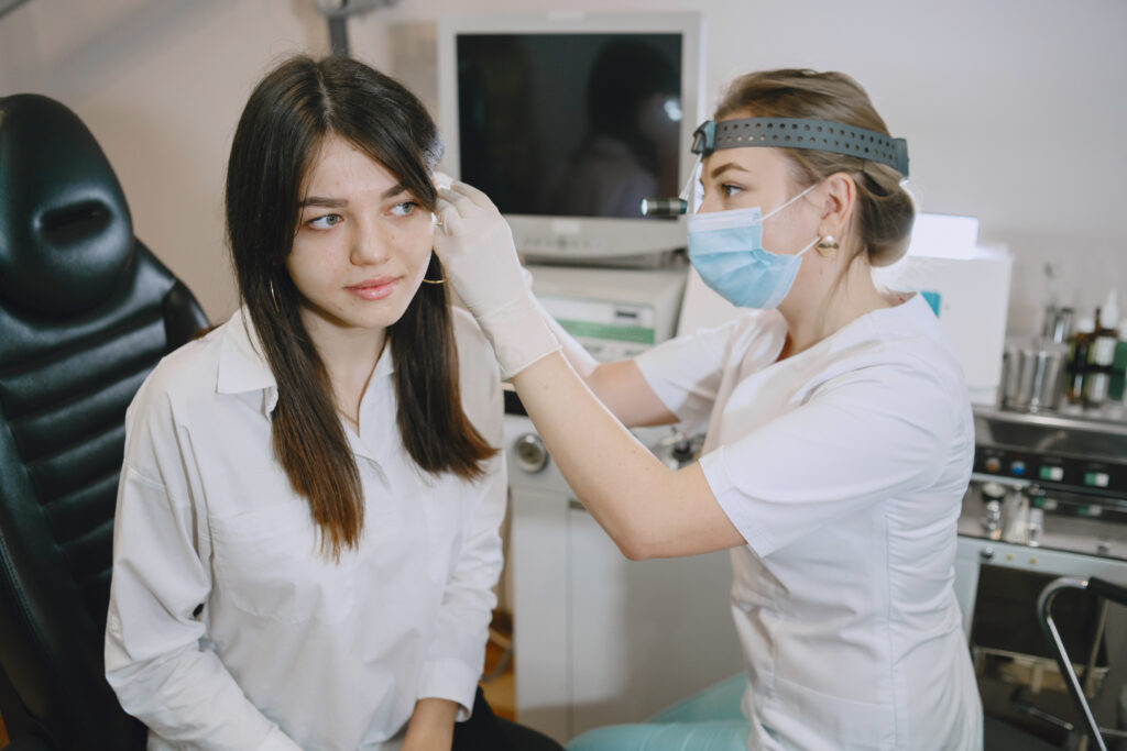 woman patient medical office doctor medical mask lor checks woman ears
