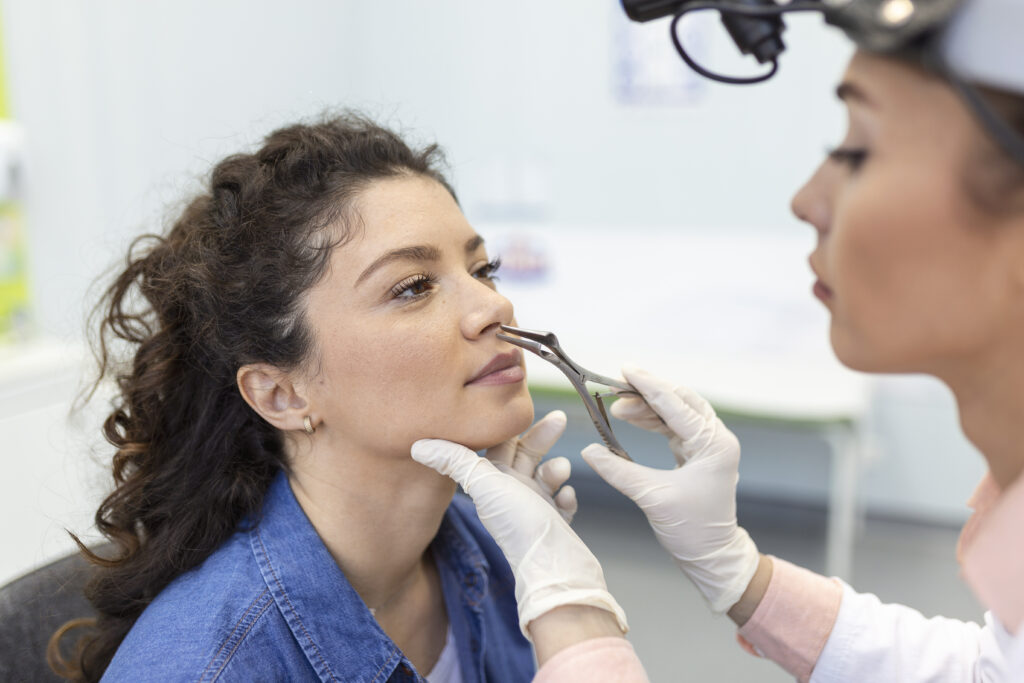 doctor otorhinolaryngologist checking nose with otoscope patient hospital nasal congestion sinusitis allergy concept