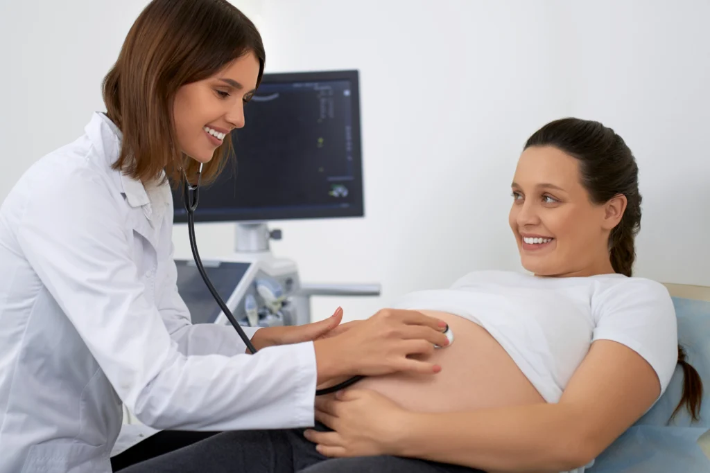 doctor using stethoscope examining pregnant woman