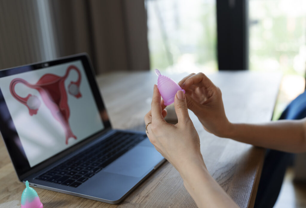 side view hands holding menstrual cup